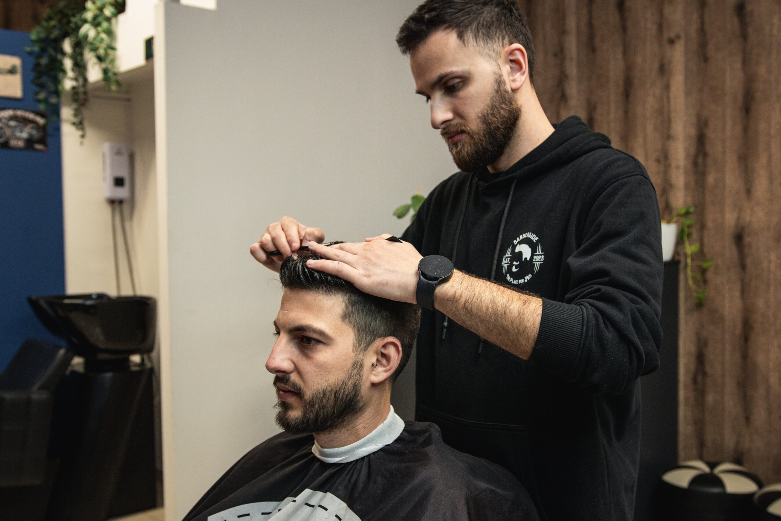 A professional barber in Larnaca styling a client’s hair with precision, using high-quality grooming products in a modern barbershop.