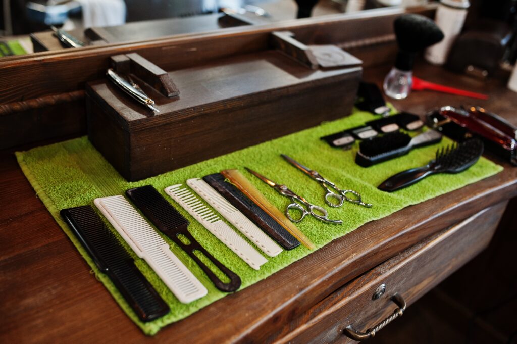 A collection of professional barber combs, scissors, and grooming tools neatly arranged on a workstation.