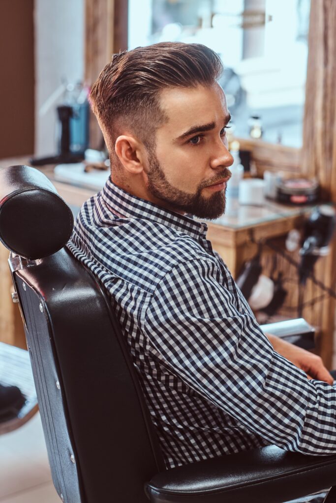 Man with fresh haircut sitting in barber chair at a stylish Larnaca barber shop