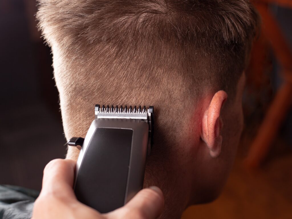 Close-up of a man getting a clipper fade haircut, one of the best hairstyles for a clean and modern look.